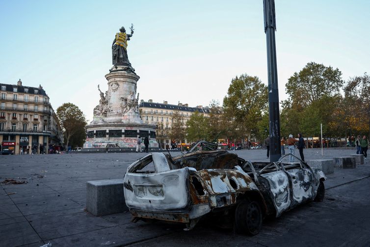 A destroyed car near the Marianne statue at the Place de la Republique, with a yellow vest put on it, the day after clashes during a national day of demonstrations against the cost of living and rising fuel prices, in Paris, France, October 18, 2026. The back of the vest reads: 'In 1961 the police drowns Algerian women'. REUTERS/Abdul Saboor     TPX IMAGES OF THE DAY